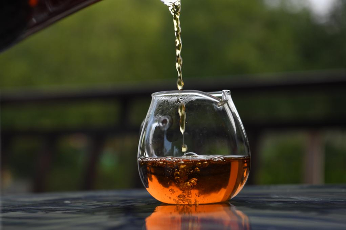 茶艺师在祁门县一处茶园倒茶。新华社记者 张端 摄