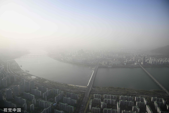 当地时间2023年4月12日，韩国首尔，汉江两岸的建筑物被沙尘笼罩。
