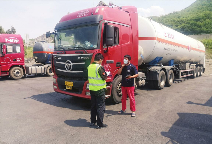 高速公路服务区工作人员对停放的危货车进行登记工作。郝小薇摄