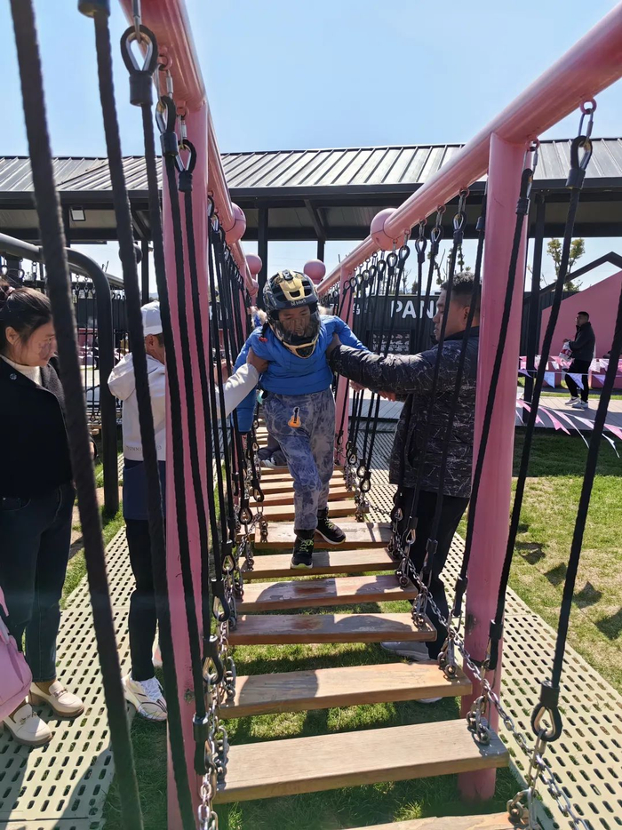 罗书坚扶着小柏，让他也能体验走秋千。