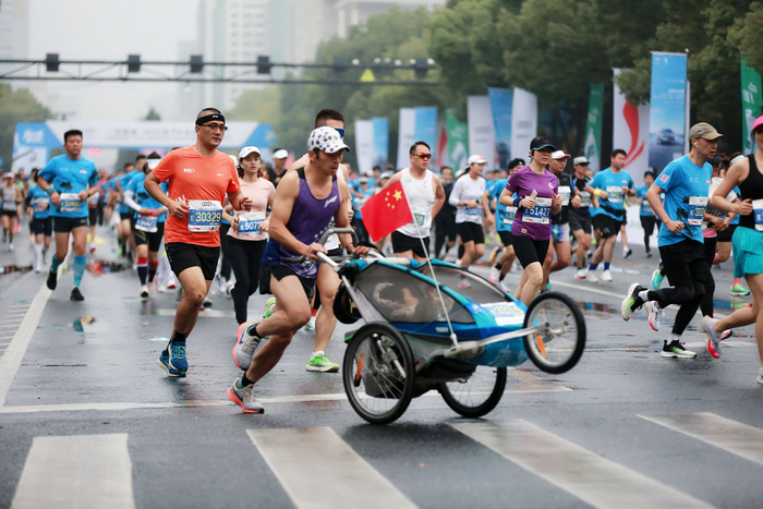 2023年4月9日，浙江兰溪，罗书坚推着儿子跑马拉松。受访者供图