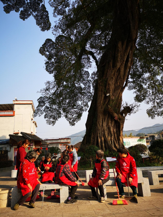 广西壮族自治区蒙山县新圩镇坝头村的千年古榕下，志愿者们打扫完村里卫生后在树下歇息。农民日报·中国农网记者 钟欣 摄