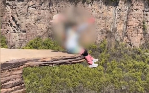 △游客在“试胆石”上打卡拍照。