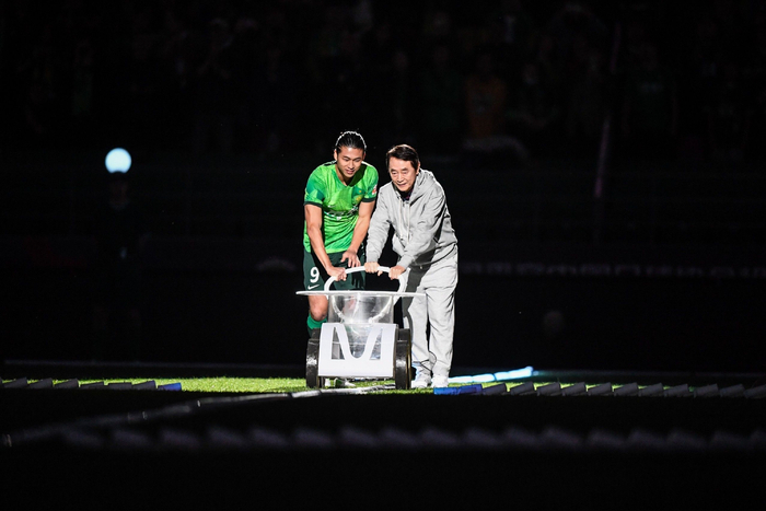 金志扬与现役球员张玉宁一起手推划线车。