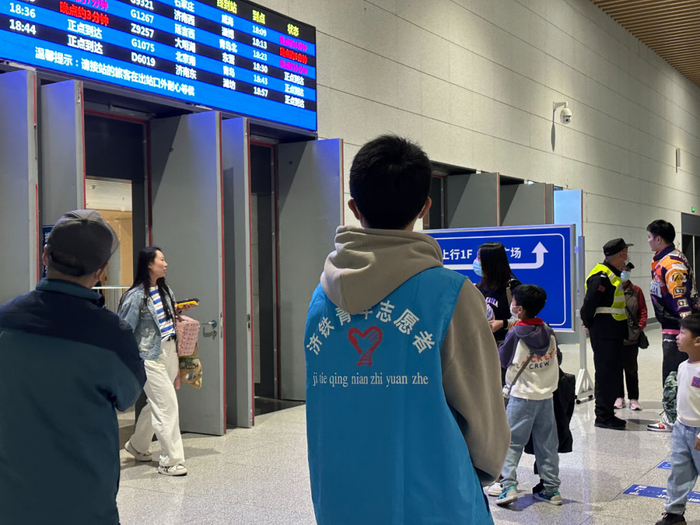 淄博火车站出站口的青年志愿者。（新华社记者 张超帆 摄）