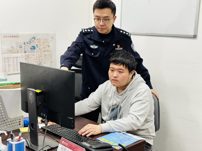 谢欢在指导北京大学反诈志愿者进行电话劝阻拦截。受访者供图