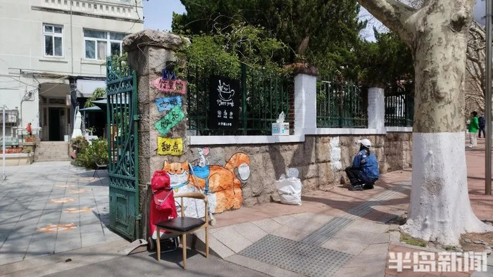 大学路上，一位墙绘师正在专注地工作。