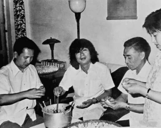 1978年，小泽征尔坐在韩中杰家里借来的沙发上，与韩中杰（左）和吴祖强（右）包饺子。