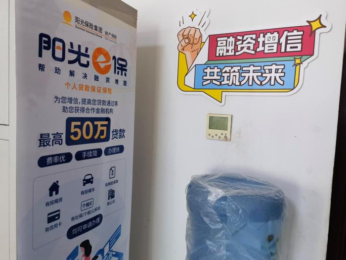 阳光财险许昌支公司内张贴的信贷业务宣传海报：费率优、手续简、办理快。  新京报记者 程亚龙/摄