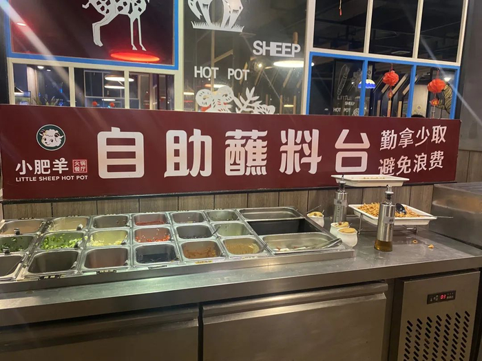 ▲火锅店提示“勤拿少取 避免浪费”。 张文章/摄