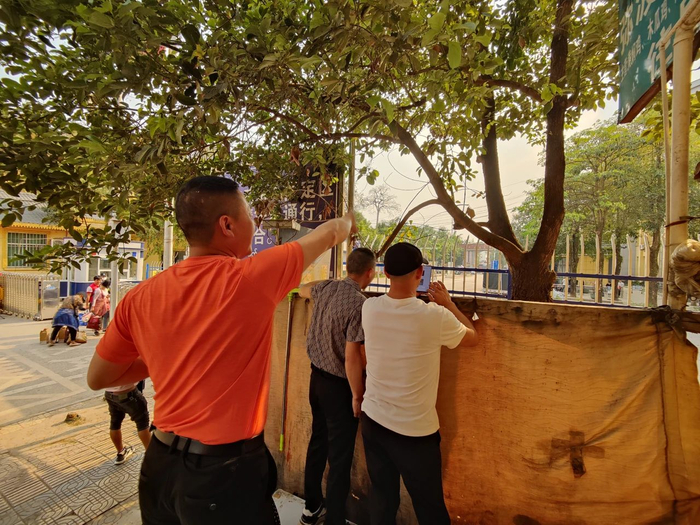 4月7日傍晚五点，清水河口岸，江西人沈望威一行三人隔着铁栏杆和儿子打招呼。新京报记者 汪畅 摄