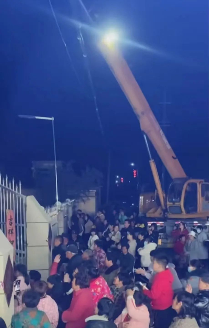 杂技团经常被请去私宅表演，房子旁边一个大吊车吊着张某进行空中表演。/张某