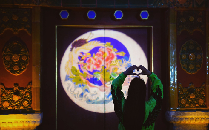 4月21日，景山公园，游客在牡丹投影前留影。新京报记者 薛珺 摄