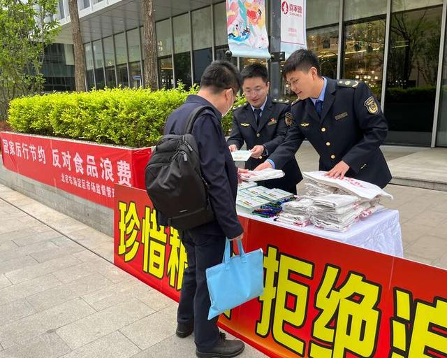 4月20日，中关村壹号，北京市海淀区市场监管局工作人员发放反浪费宣传手册。中青报·中青网记者 张艺/摄