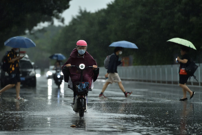 4月21日下午，广东广州，市民在雷雨中出行。图/视觉中国