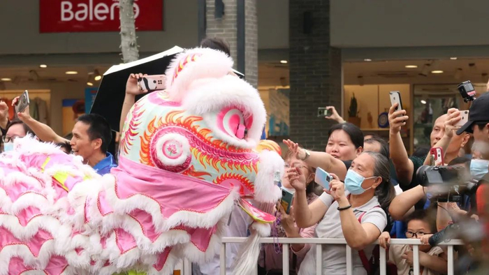 岭南醒狮方阵走过时，沿途市民争相拍照，摸摸狮子头祈求更加好运顺利。