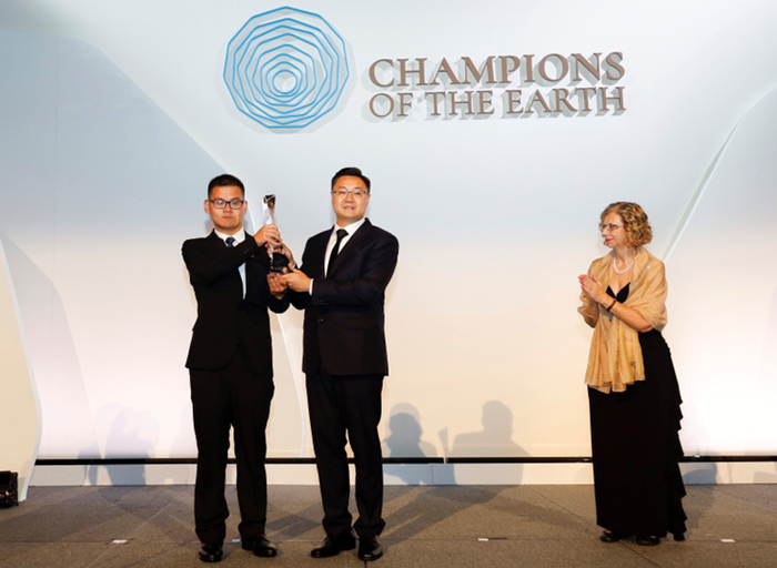 蚂蚁森林用户沈钧亮（左一）与徐笛捧起“地球卫士奖”