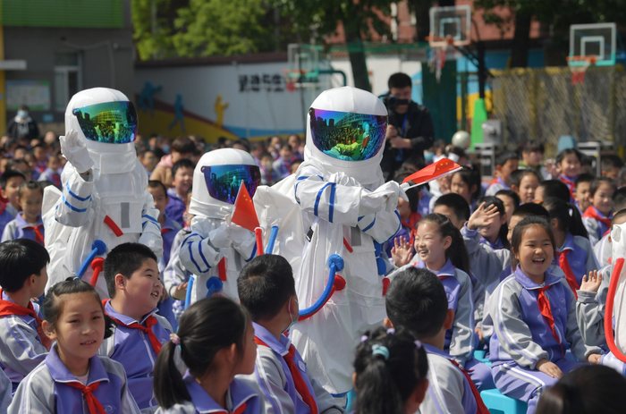 “航天员”走进学生中间，和学生们互动。新京报记者 李木易 摄