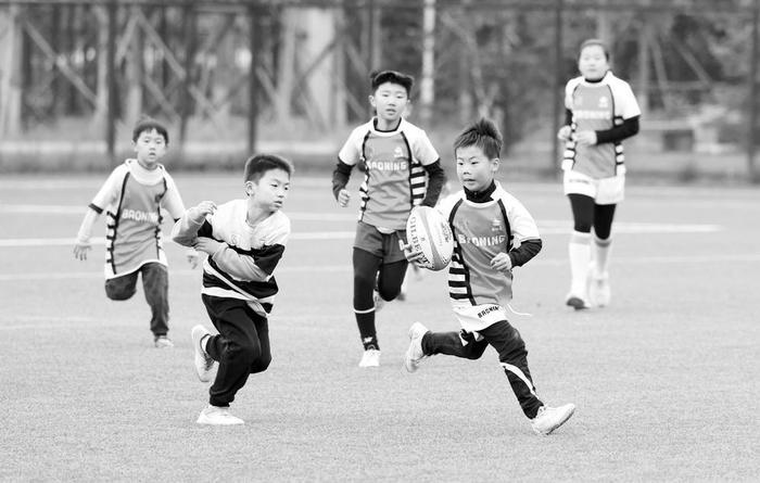 　　图为小队员们体验橄榄球运动的快乐。　　本报记者 梁子栋 摄