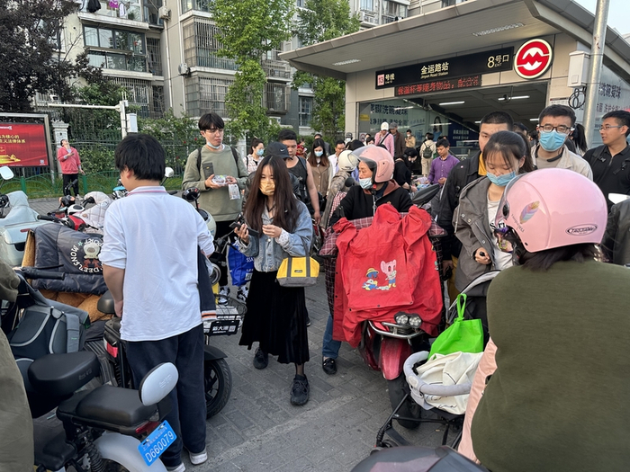 金运路站外，出站人流与非机动车混行。