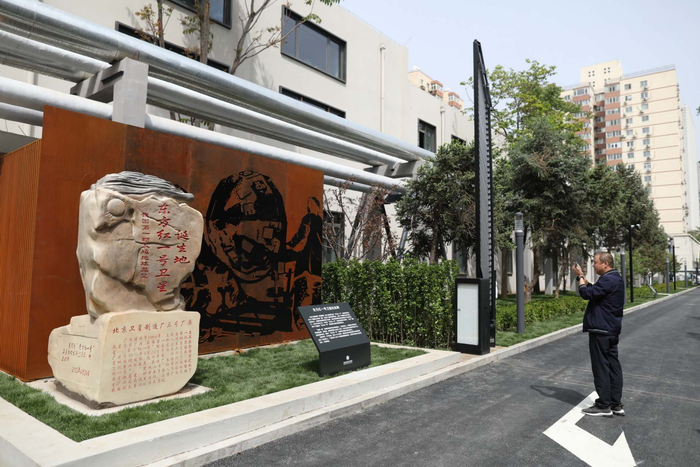 市民拍摄“东方红一号”卫星诞生地纪念碑，后面就是总装“东方红一号”卫星的三号厂房。  新京报记者 浦峰 摄