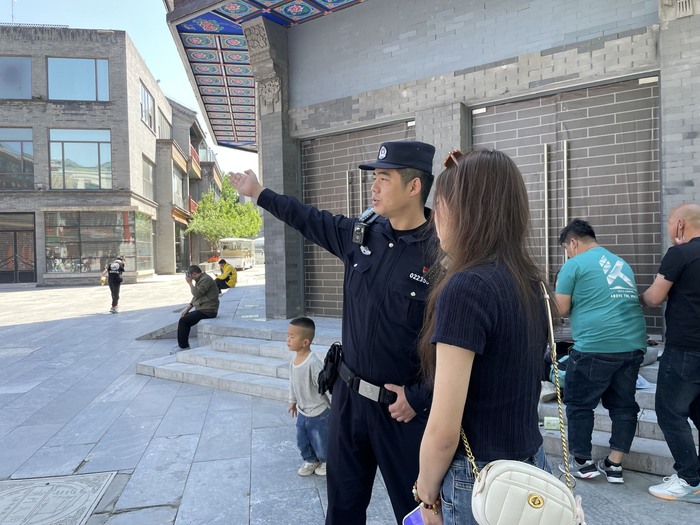 执勤巡逻中，张召龙给游客指路。新京报记者 张静姝 摄