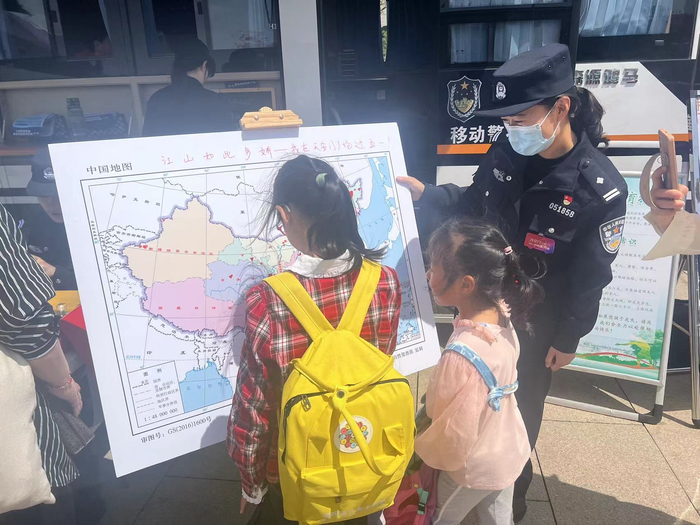 移动警务车旁边，民警在给儿童游客讲解打卡地图。新京报记者 张静姝 摄