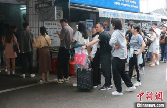 图为游客在柳州螺蛳粉店前排起长龙。 中新社记者 林馨 摄