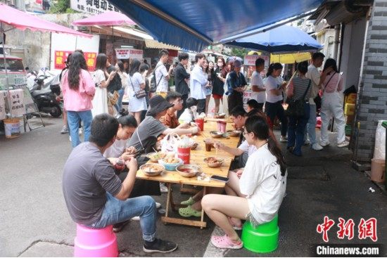 图为游客在柳州螺蛳粉店前排起长龙。 中新社记者 林馨 摄