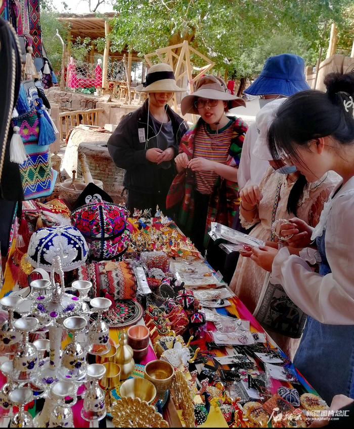 在吐峪沟村，游客们在购买工艺品。记者 贾春霞摄