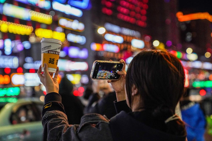 游客手拿咖啡在延吉市打卡拍照。新华社记者 颜麟蕴 摄