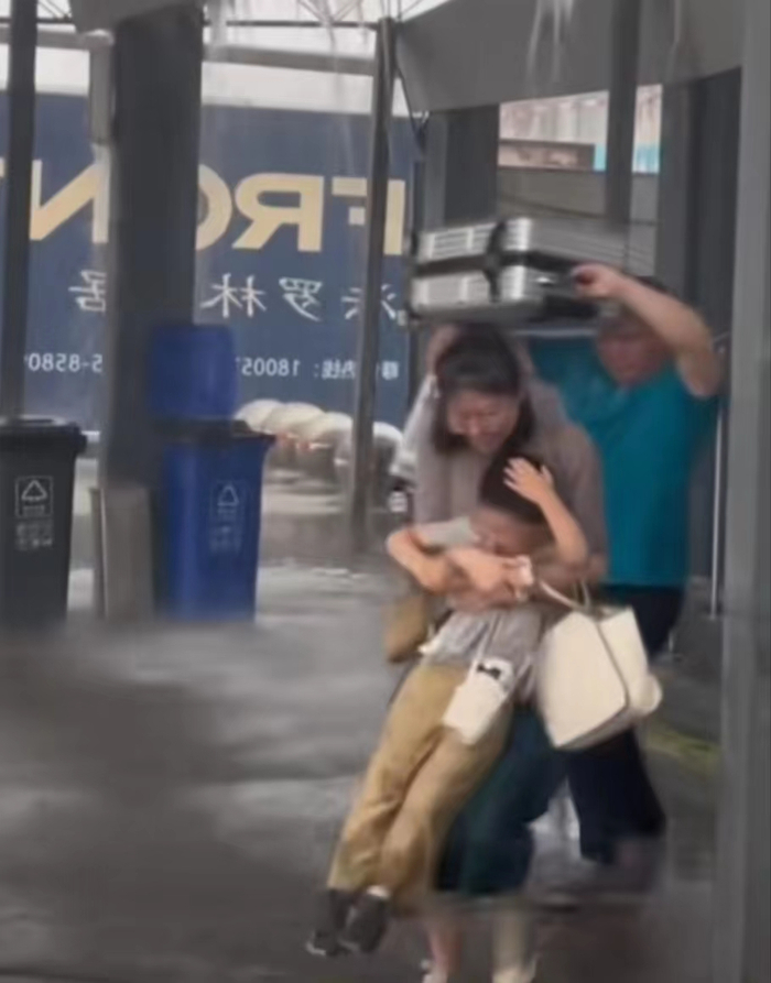 ▲乘客用行李箱挡雨。