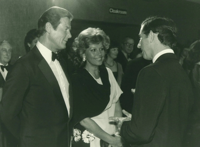 1977年，当时还是王子的查尔斯在《海底城》首映礼上同罗杰·摩尔等主创握手交谈