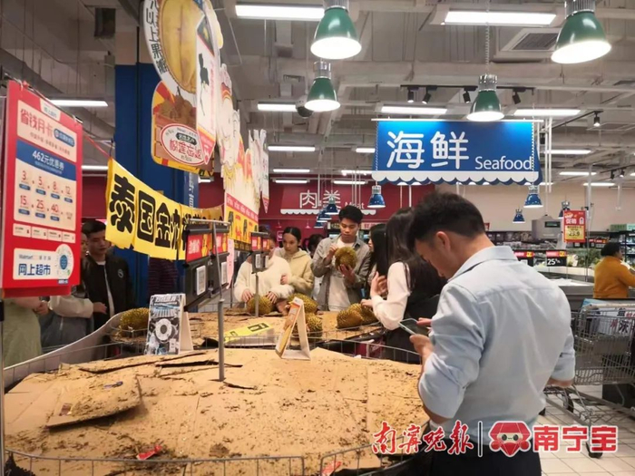 ▲市民在超市内等候榴莲“补货”    本报记者  廖欣  摄