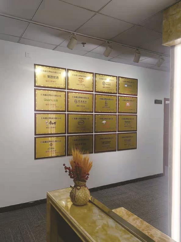             墙上挂着16块合作企业的铜牌，但落款时间都在“郡达物流”成立之前          