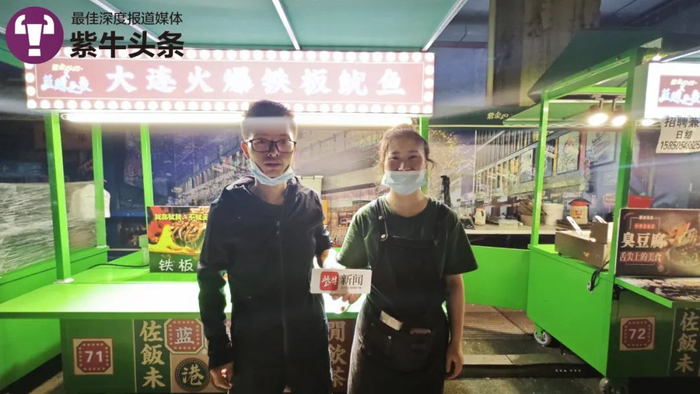 赵亮和妻子在鱿鱼摊前接受记者采访