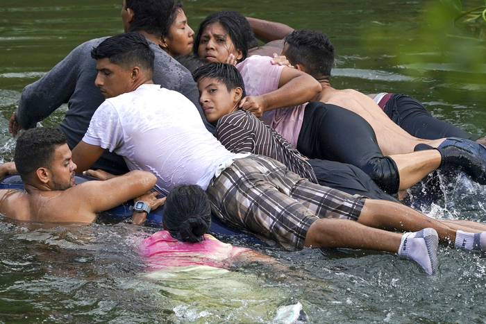 当地时间5月9日，墨西哥马塔莫罗斯，偷渡客躺在充气床垫上穿过布拉沃河准备进入美国。