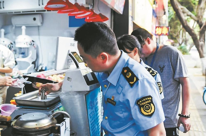     执法人员对沿街商户的电子秤进行检查