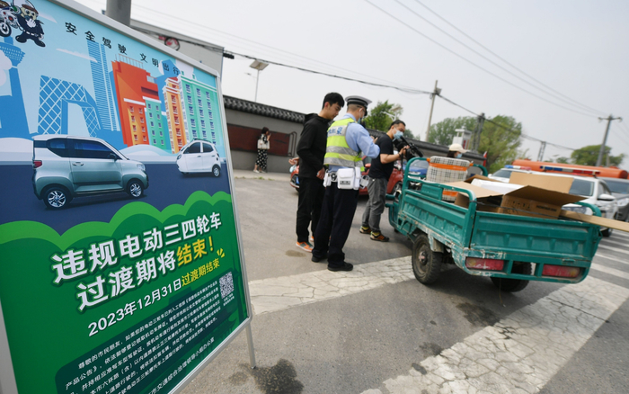 交管部门对违规电动三、四轮车过渡期政策进行现场宣传。新京报记者 王贵彬 摄