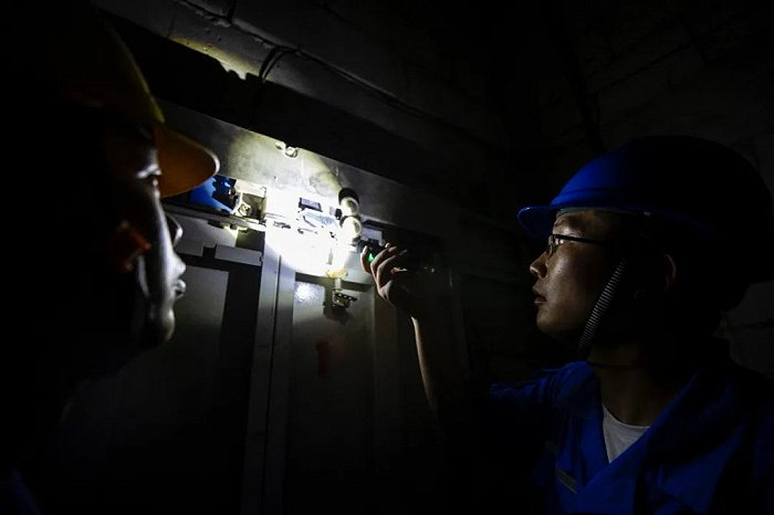 滨湖一楼栋的电梯内，工作人员在电梯井道里进行检测。高博 摄