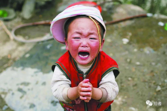▲2008年5月16日，四川青川山边的一户人家，孩子在妈妈身边抬着双手哭了起来。摄影 / 韩萌