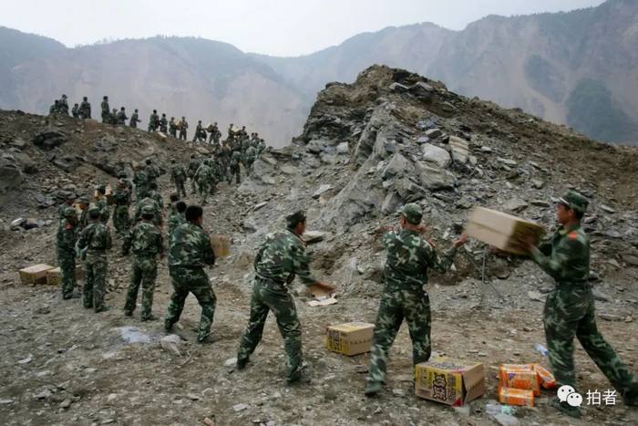 ▲2008年5月27日，绵阳市唐家山堰塞湖，抢险战士在搬运各种物资。摄影 / 浦峰