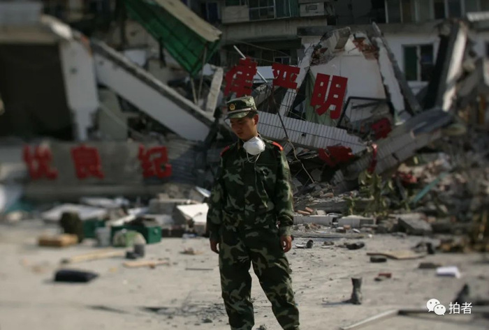 ▲2008年5月19日，一名参加救援的军人在倒塌的建筑前。摄影 / 韩萌