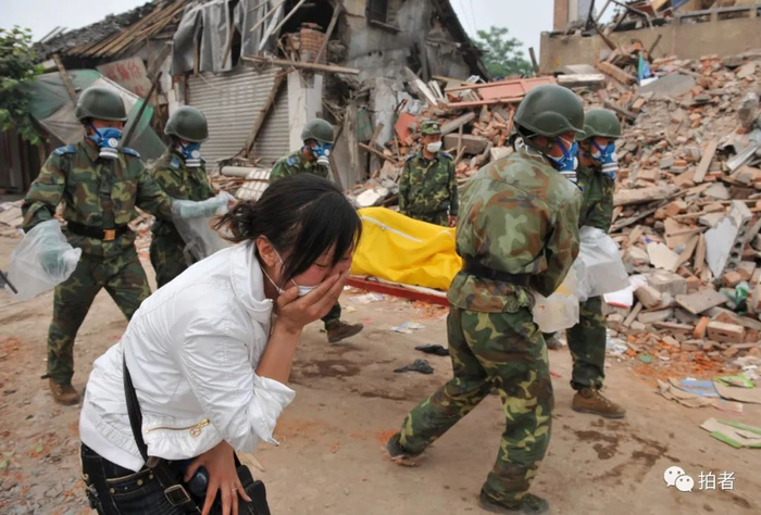 ▲2008年5月16日，四川省德阳市永泉镇，一名悲痛的女子，解放军战士在废墟中找到她的亲人，但已经去世。摄影 / 陈杰