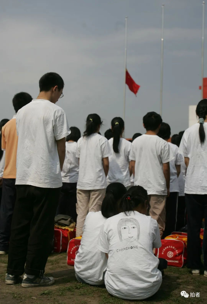 ▲2008年5月19日，北川中学复课，两位学生依偎在草地上为遇难者祈福。摄影 / 韩萌