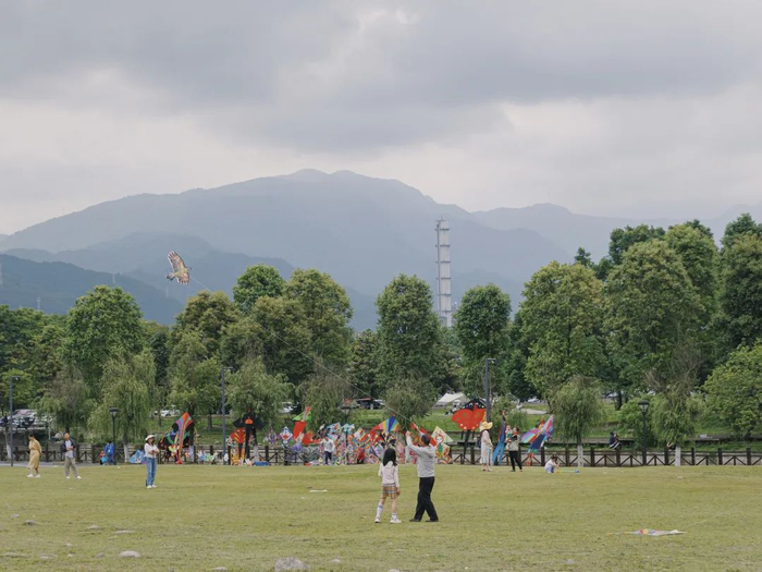 ▲2023年5月7日，都江堰市，人们在草坪上露营、放风筝。
