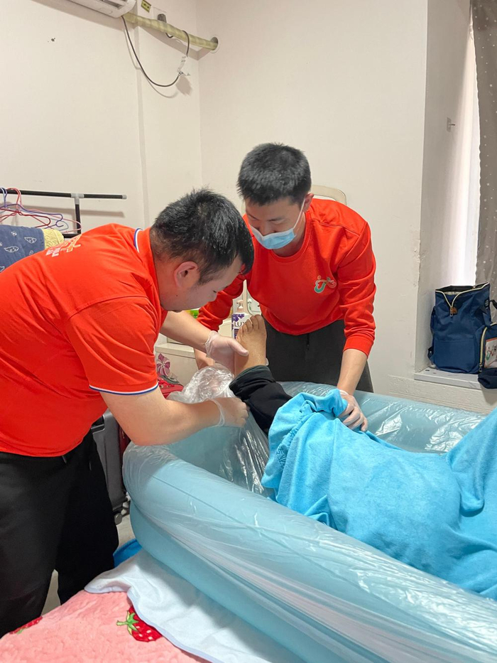 在位于成都市双流区的一个小区里，四川福乐家综合养老服务有限责任公司助浴师晏杨俊祺（右）和同事刘福鑫为失能老人提供助浴服务（3月16日摄）。新华社发（张羽飞摄）