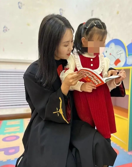     2023年3月，青海省海东市互助县人民法院，法官谢彩金在家事法庭亲子活动室陪果果看书。互助法院供图