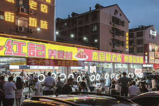 红记美食村人气火爆，食客满座，热闹非凡，18位网红主播对美食进行宣传推荐。曹向东 摄