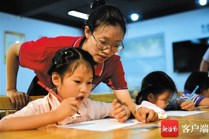 洪美叔手把手教孩子画画。新海南客户端记者 陈卫东 摄
